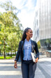 © unai - Stylish latin businesswoman walking along the city