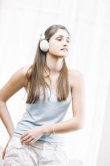 Wall Mural - Young woman listening music with headphones at home