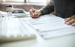 © Lek - Asian businessman reviewing document reports at office workplace. legal expert, professional lawyer reading and checking financial documents or insurance contract before sign