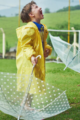 Wall Mural - Rain, umbrella and kid with mouth open for outdoor fun, happiness and growing up in wet coat. Winter, boy or child in park to taste or catch water drops for freedom, cold weather or playing alone