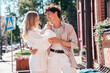 © halayalex - Smiling beautiful woman and her handsome boyfriend. Woman in casual summer clothes. Happy cheerful family. Female having fun. Couple posing in the street it sunny day. Cheerful and happy