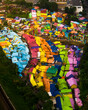 © AmazingAerialAgency - Aerial view of colorful rooftops and houses in a vibrant village, Blimbing, East Java, Indonesia.