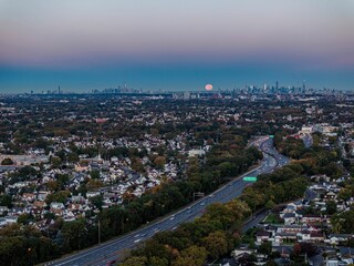 Aerial view of suburbia leading to city skyline at dusk.