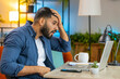 © Andrii Iemelianenko - Angry furious Hispanic man freelancer using laptop while working at home office having nervous breakdown at work, stress management, mental distress problems, losing temper, reaction on failure.