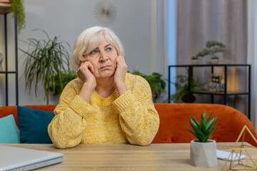 Portrait of sad stressed senior grandmother woman sitting at home looks pensive thinks over life concerns, suffers from unfair situation. Problem crisis depression feeling bad sick ill annoyed burnout