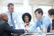 © STEEXBuyout/peopleimages.com - Happy, business people or meeting with handshake for contract, teamwork or deal together at office. Businessman, colleagues or employees shaking hands for agreement, b2b or collaboration at workplace