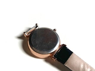 Closeup image of wristwatch with strap against white background. Backside of wristwatch.