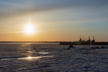 Wall Mural - Winter landscape with Baltic sea at sunset. Ships are moored at port