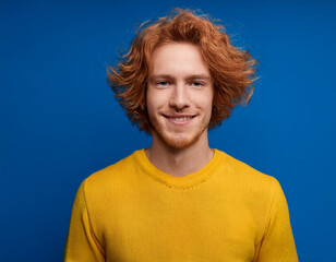 Wall Mural - Portrait of Young Handsome Man Happily Smiling Against Blue Studio Background