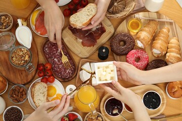 Sticker - Women eating different food during brunch at wooden table, top view