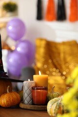 Canvas Print - Burning candles and pumpkins on wooden table indoors, space for text. Halloween celebration