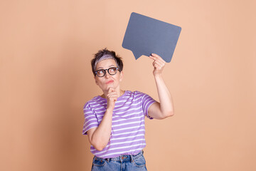 Sticker - Photo of dreamy clever woman wear striped stylish clothes hand hold empty space isolated on beige color background