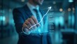 © natakot - A glowing digital graph projected above a hand in a dark office, symbolizing growth, technology, and future business trends. The image highlights innovation and financial progress.