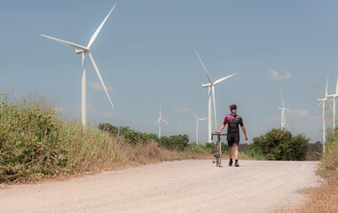 Cyclists are riding their bikes for training and touring the wind farms