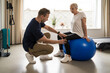 © Lomb - Physical therapist assisting senior woman with stability ball exercise, rehabilitation, active aging