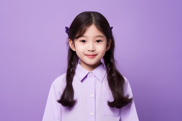 Wall Mural - Portrait of a cute little asian girl in purple shirt on purple background