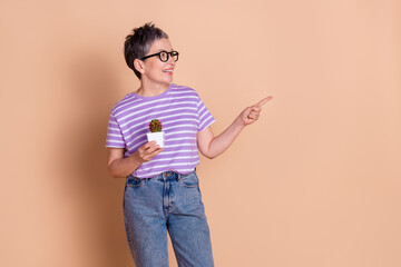 Sticker - Photo of pretty cute woman wear striped stylish clothes hold cactus flower empty space isolated on beige color background