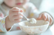 © Athichai - Infants under 1 year old are learning to use a spoon to put liquid food into their mouths by themselves.