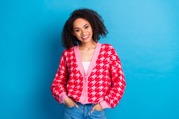 Wall Mural - Portrait photo of candid smile american beautiful girl with curly hair wearing red stylish cardigan isolated on blue color background