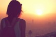 © Konstiantyn Zap - Silhouette of woman watching sunset over cityscape
