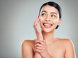 © KayExam/peopleimages.com - Face cream, mockup and woman with skincare in studio with nourishment, hydration and glow. Happy, health and female person with facial moisturizer for beauty dermatology routine by gray background.