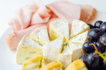 A plate of food with bread, cheese, and grapes