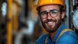 © angel_nt - A cheerful construction worker wearing a hard hat and glasses poses confidently in a bustling industrial environment, emphasizing safety and professionalism
