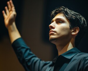 A focused young man raises his hand in a moment of expression, capturing the essence of passion and determination.