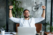 © s1llu - Joyful Man Celebrating Success in Modern Office
