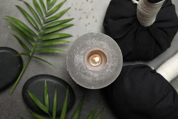 Canvas Print - Spa composition with herbal bags and burning candle on grey table, flat lay