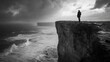 © Nonnarit - A person standing on a cliff overlooking the ocean during a storm, with wind and rain whipping around them