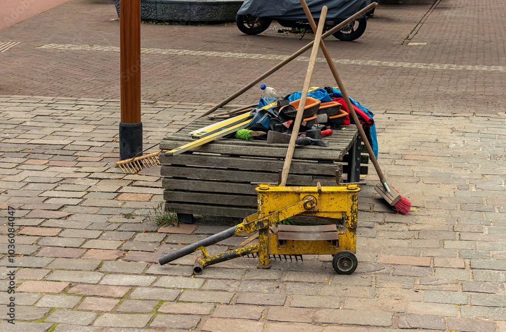 various paving tools lie outside on a wooden bench