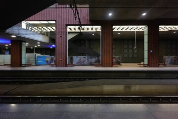 Empty modern train station platform with illuminated lights and advertising posters in Anvers