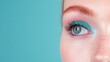 © Elysian Essence - Close-up of a freckled face with blue eye, vibrant turquoise eyeshadow, long lashes, glowing skin, radiant blush, artistic and modern beauty concept, soft pastel background