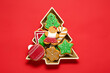 © Pixel-Shot - Delicious cookies in Christmas tree-shaped bowl on red background