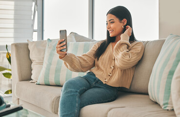 Woman, selfie and home with social media, profile pciture and smile on living room sofa. Tech, happy and influencer with vlog, photograph and relax on the weekend with day in the life video to post