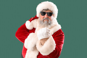 Bad Santa Claus showing vulgar gesture on green background