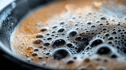 Wall Mural -   A close-up of liquid in a pan, water at the bottom, lots of bubbles