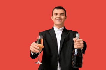 Poster - Young man with bottle and glass of champagne celebrating Christmas on red background