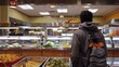 © Sam - A young man stands in a cafeteria line, looking over the food options.