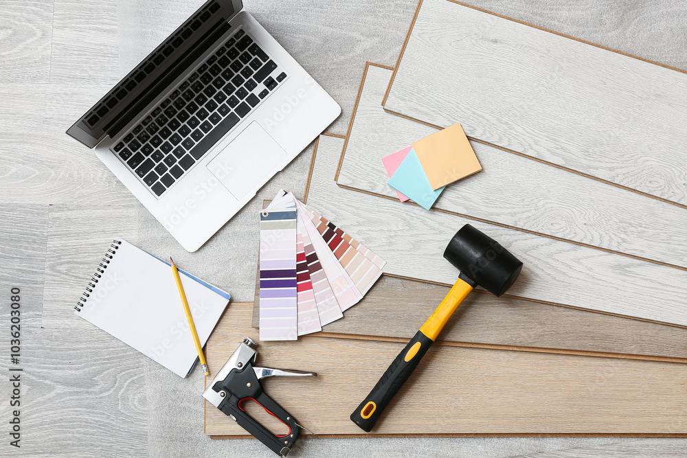 Tools, laptop, color palettes and laminate boards on floor