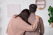 © Pixel-Shot - Young couple hugging at home on autumn day, back view