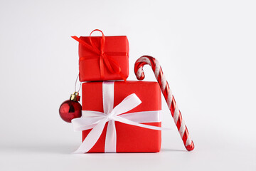 Christmas gift boxes with ball and candy cane toy on white background