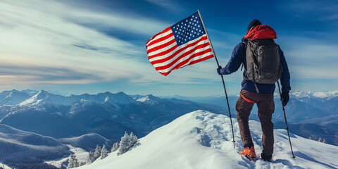 Hiker standing on mountain peak holding american flag