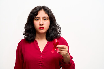 Wall Mural - Serious young Latina woman, holds red World AIDS Day ribbon