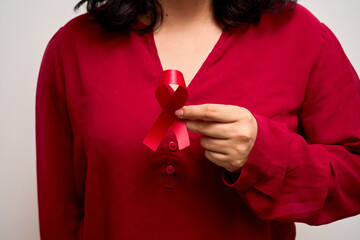 Wall Mural - Young Latin woman, holding red World AIDS Day ribbon