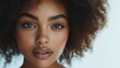 © ifoto - Beautiful black woman with natural makeup and curly hair posing on a white background