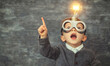 © Eddy Drmwn - A young boy wearing goggles has a light bulb above his head and points up with an idea.