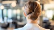 © Pannee - Elegant Woman with Chignon in Modern Workspace