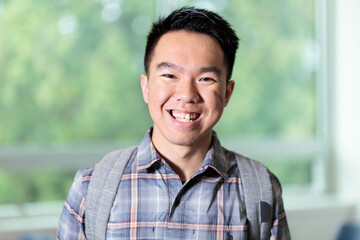 Young male teenager with a happy toothy grin at the camera